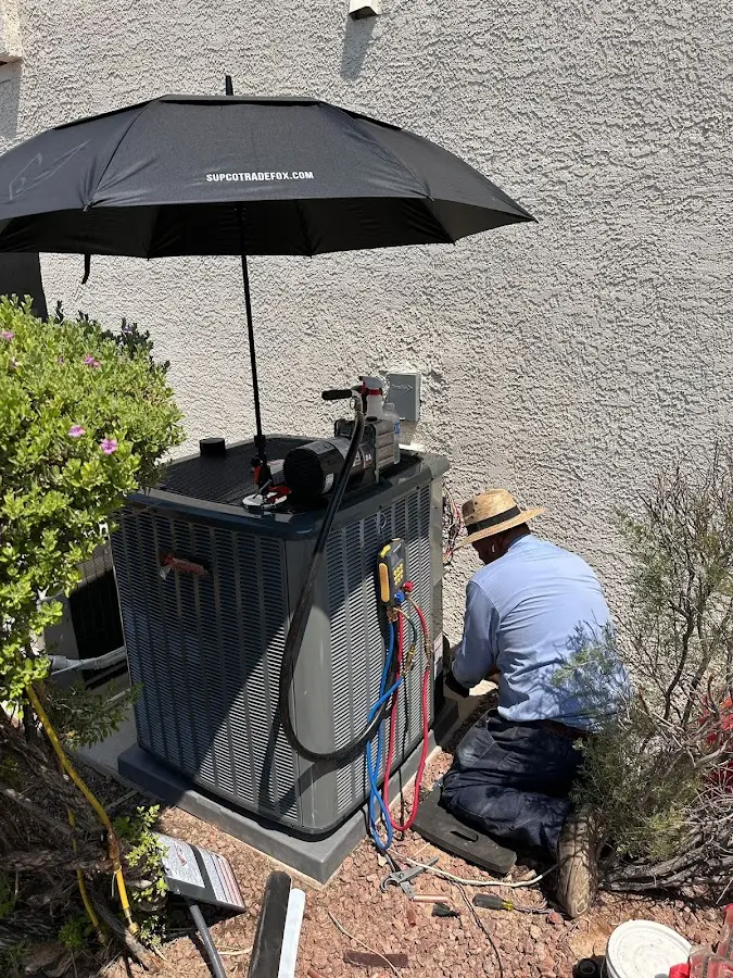 HVAC technician performing outdoor AC maintenance in Stockton