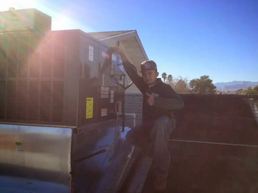 HVAC technician performing Air Duct Cleaning on a rooftop unit in Stockton